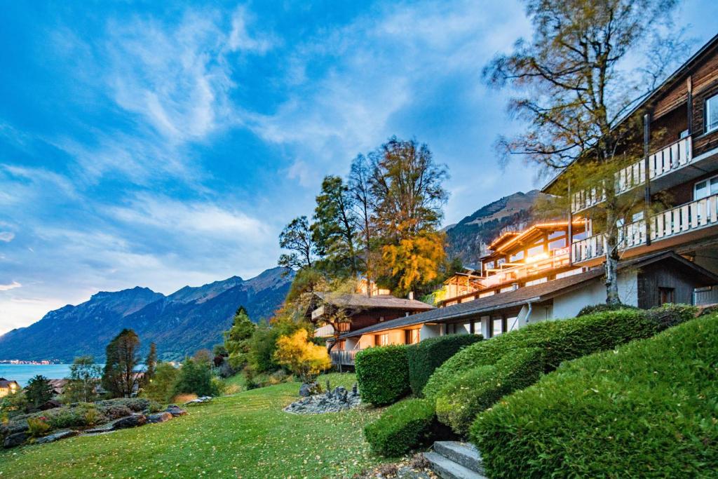 a resort with a view of the water and mountains at Hotel Lindenhof by Crossworld AG in Brienz