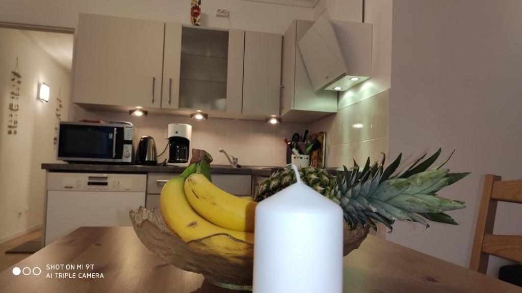 un tazón de plátanos sentado en una mesa junto a una botella de agua en Strandfee, en Grömitz