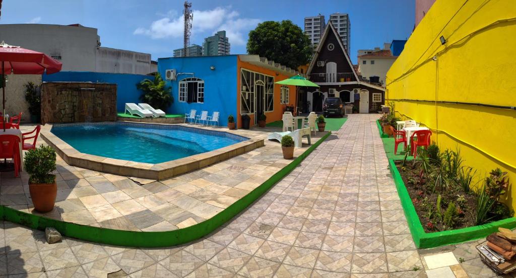 a swimming pool in a courtyard next to a building at Pousada Alojaki Hostel in Praia Grande
