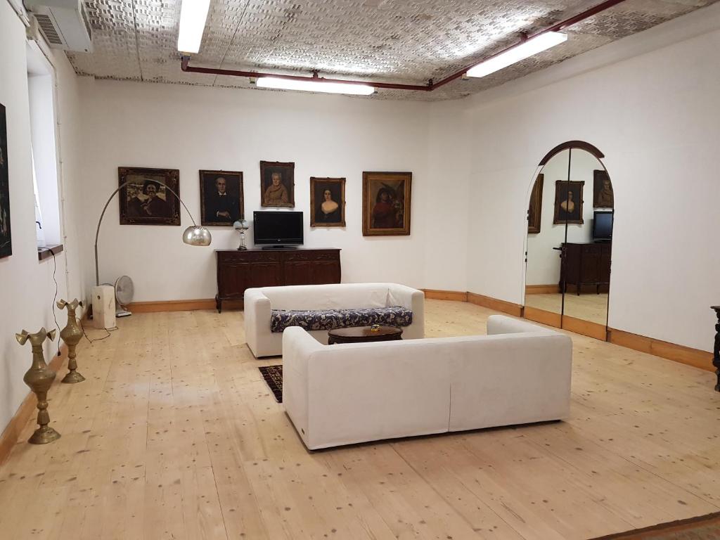 una sala de estar con 2 sofás blancos en una galería en Flower Cozy room, en Venecia