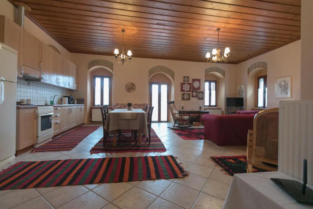 a large kitchen and living room with a table at Sophia's Stone House in Dhimitsana