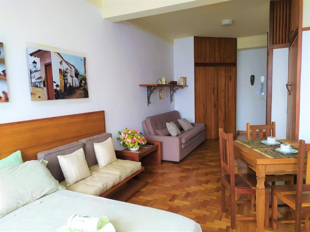 uma sala de estar com um sofá e uma mesa em Flat aconchegante no Centro Histórico em São João del Rei