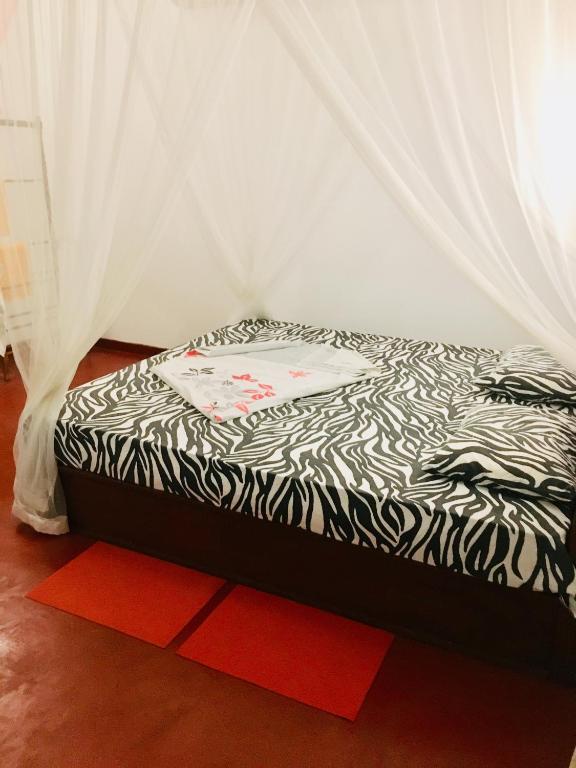 a bed in a room with a black and white comforter at Vivid Lanka in Bentota