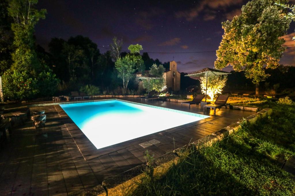 a swimming pool in a yard at night at Bergerie du Prunelli in Cauro