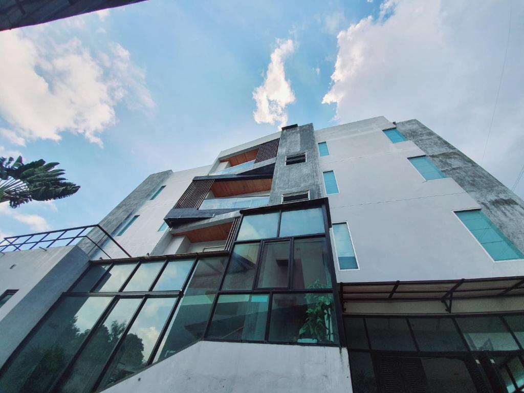a tall building with glass windows on the side of it at Lemonade Phuket Hotel -SHA Plus in Chalong