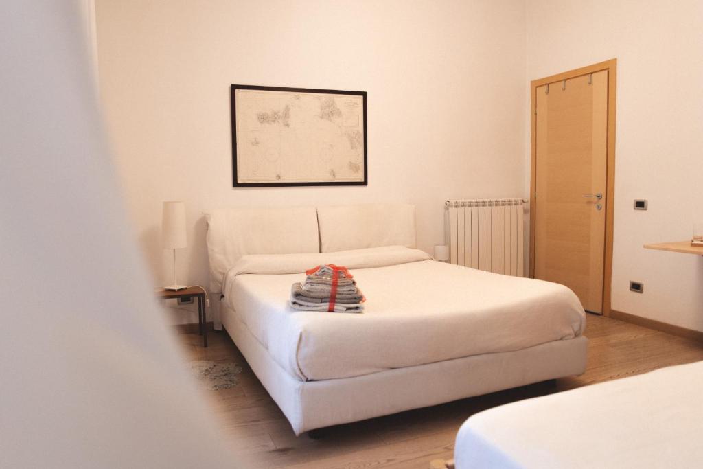 um quarto com uma cama branca e uma fotografia na parede em Accogliente Casa Livorno em Livorno