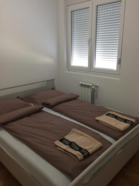 a bedroom with two beds with towels on them at Apartman PEŠAČKA ZONA in Šabac