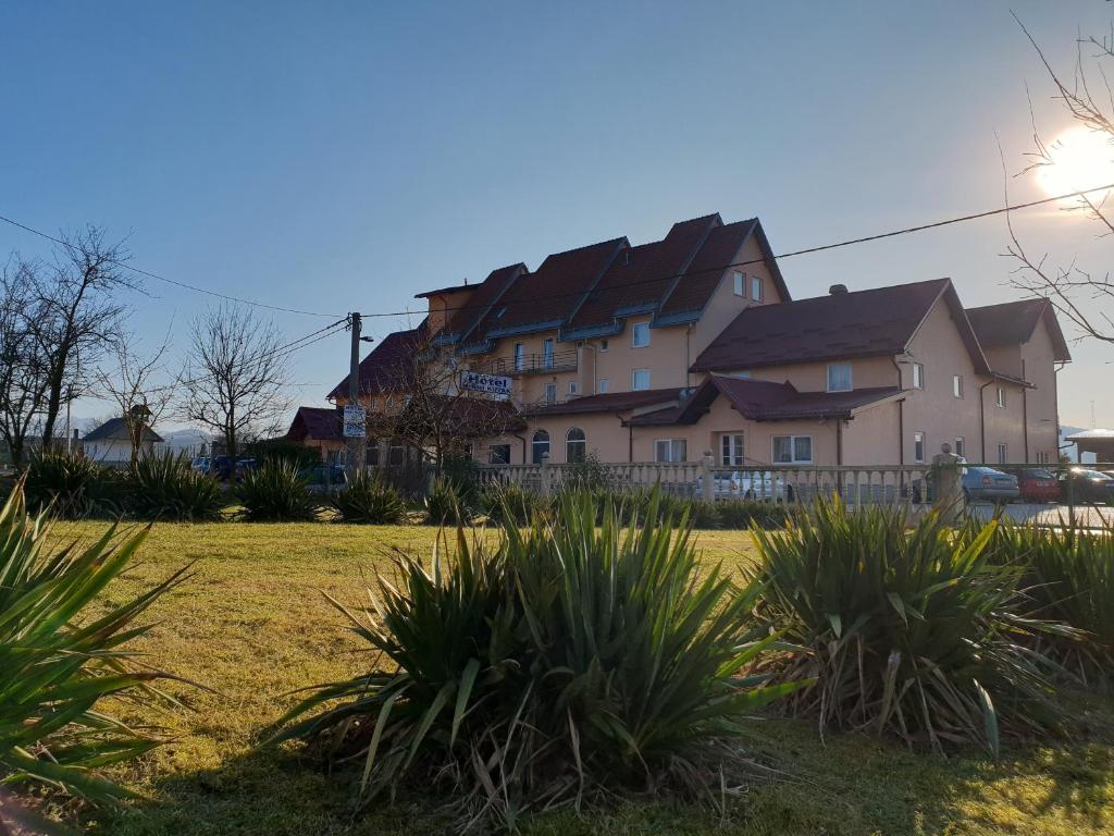 a large house in a field with plants at Hotel Mirni Kutak in Otočac