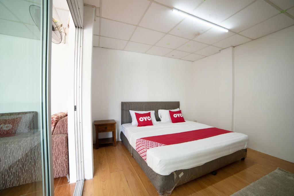- une chambre avec un lit doté d'oreillers rouges dans l'établissement OYO 457 Panasan Villa, à Bangkok