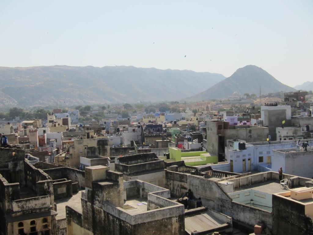 a city with buildings and mountains in the background at Hotel Everest in Pushkar