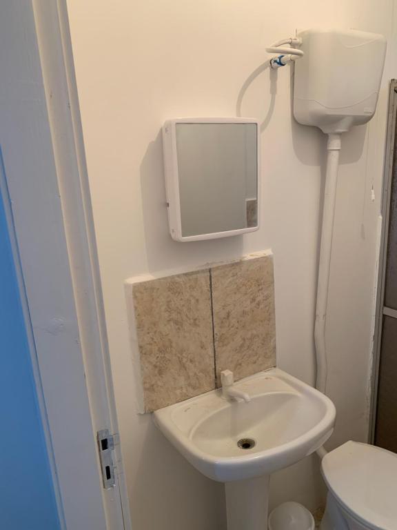 a bathroom with a sink and a mirror on the wall at Apartamento beira da Praia das Ondinas in São Lourenço do Sul