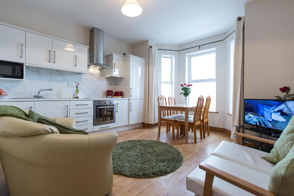 a kitchen and living room with a couch and a table at 8 Aileach in Buncrana