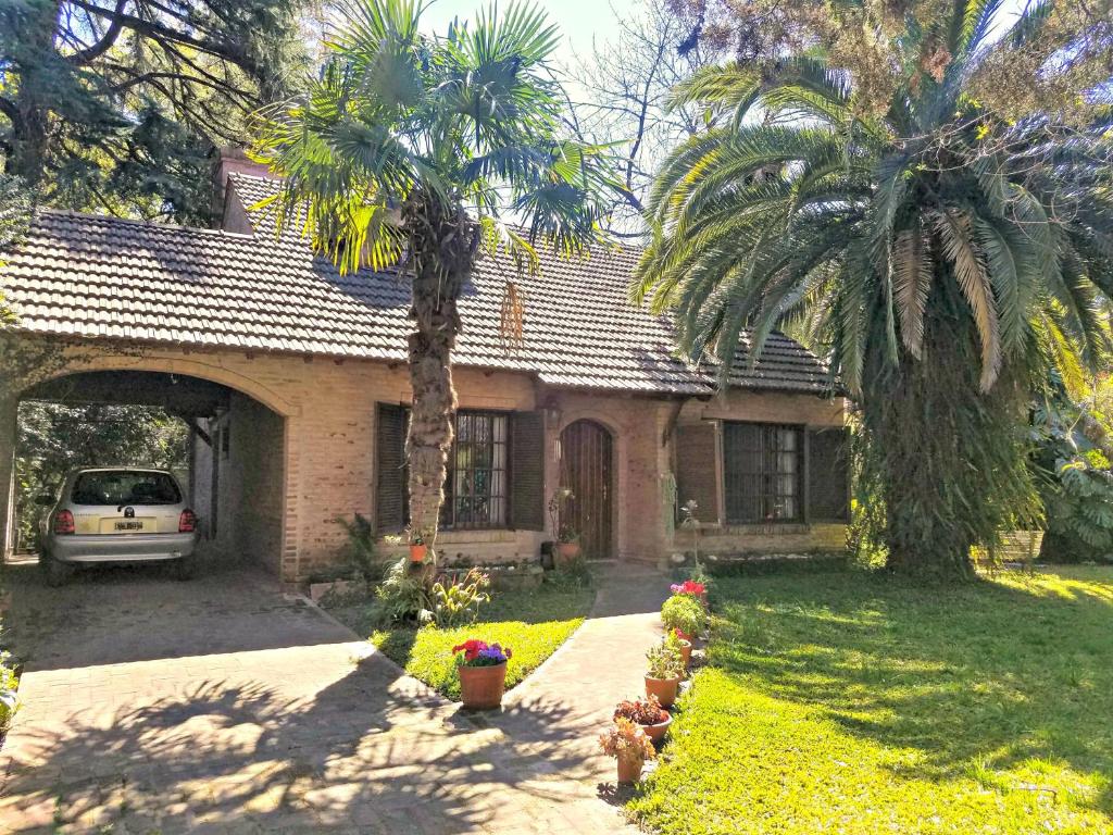 a house with a palm tree in front of it at Rosalia Suites in Loma Hermosa