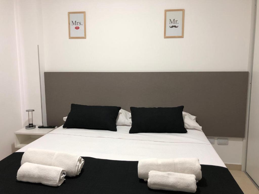a bedroom with a large bed with two towels on it at ALIWE ( A 300 metros del Aeropuerto El Palomar) in El Palomar