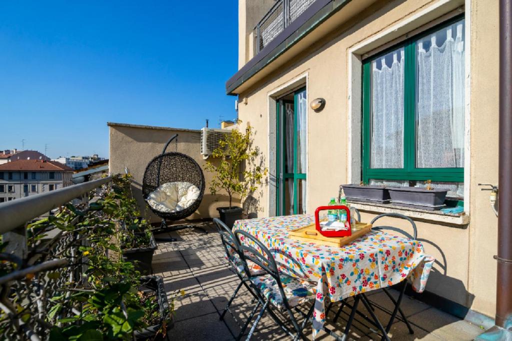 eine Terrasse mit einem Tisch und Stühlen auf dem Balkon in der Unterkunft Coni Zugna in Mailand