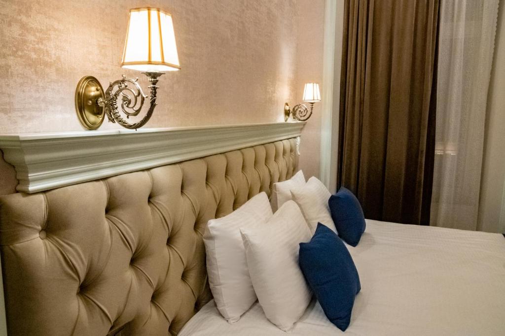 a hotel room with a bed with blue and white pillows at La Casa Sahil in Baku