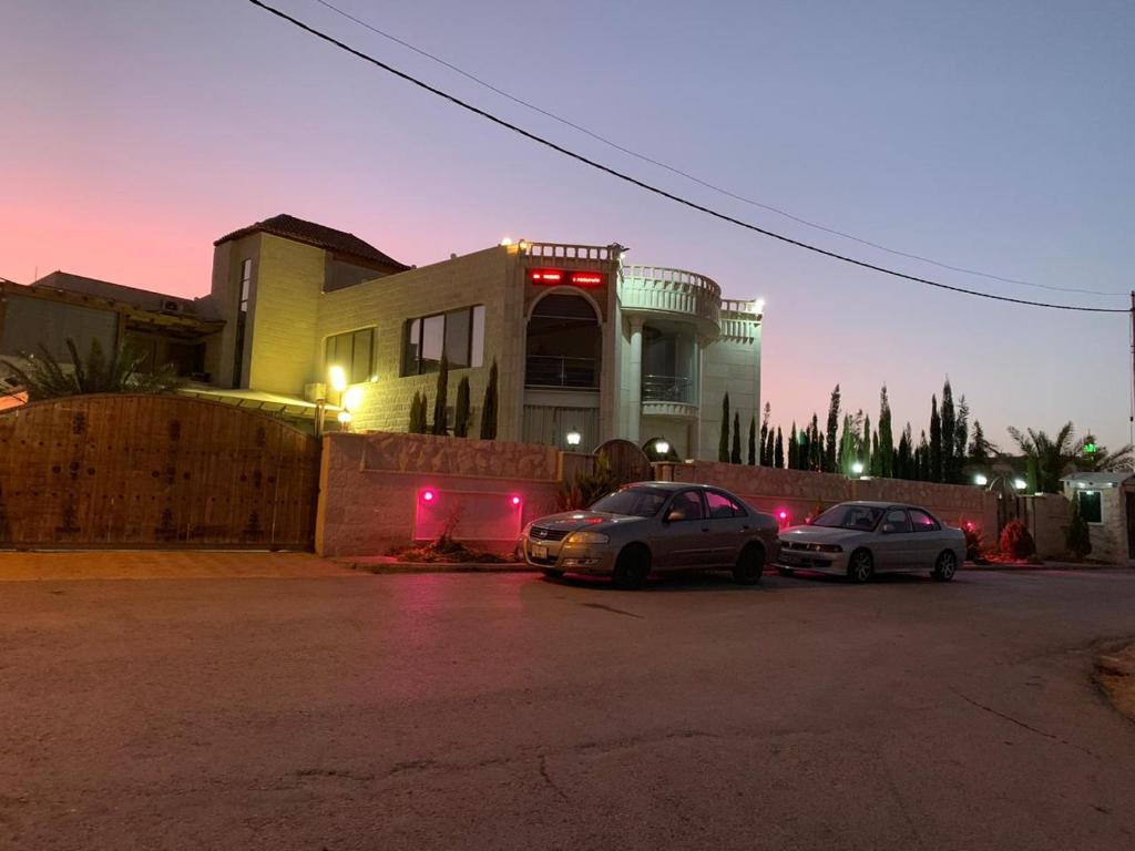 two cars parked in a parking lot in front of a house at Panorama Al-Jabal in Az Zarqa