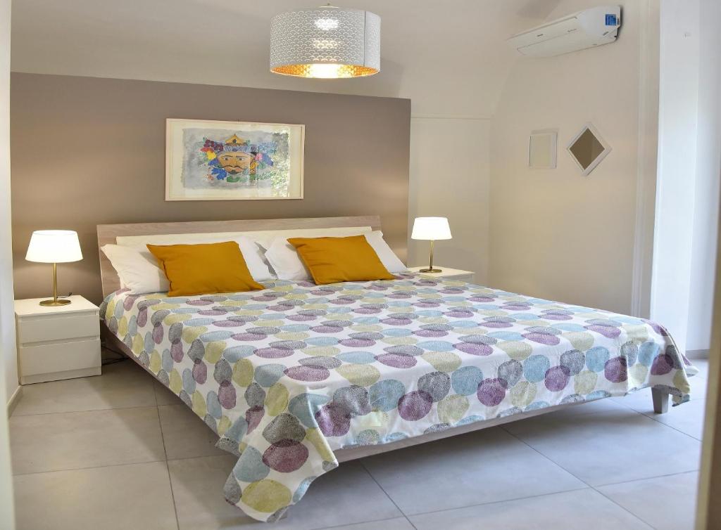 a bedroom with a large bed with two lamps at Benedettini - exclusive apartments & monastery view in Catania