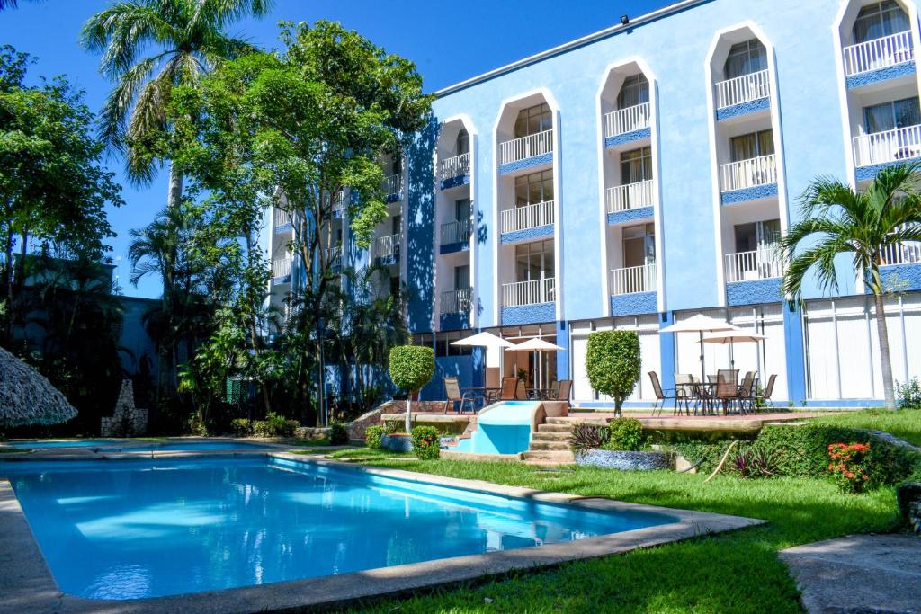 a swimming pool in front of a building at Hotel Maya Palenque in Palenque