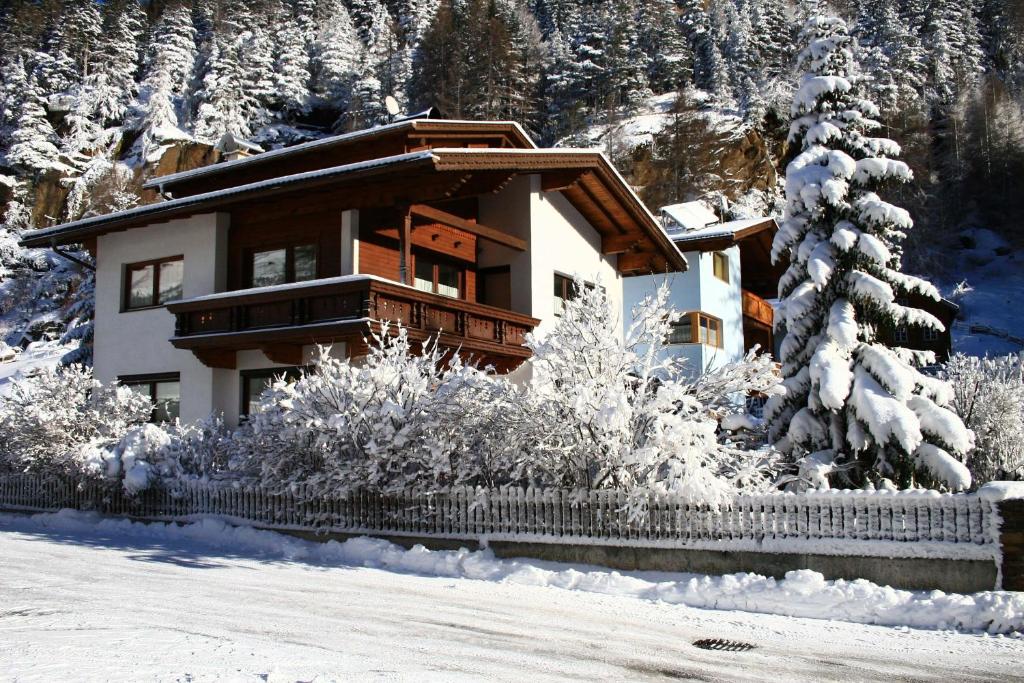 een huis in de sneeuw met een hek bij Ferienwohnung Scheiber in Sölden