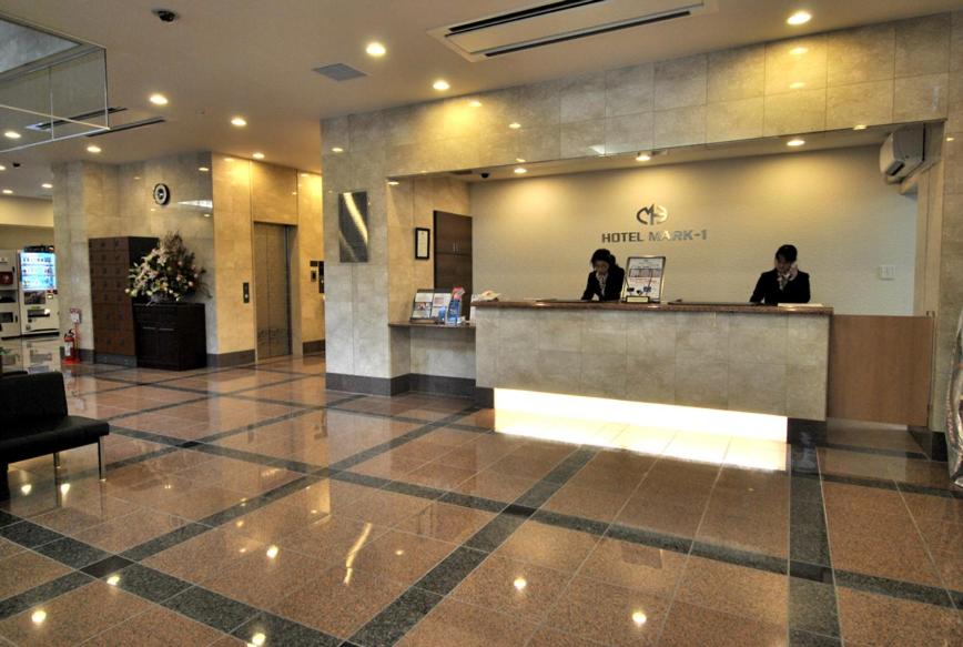 a lobby with two people standing at a counter at Hotel Mark-1 Tsukuba in Tsukuba