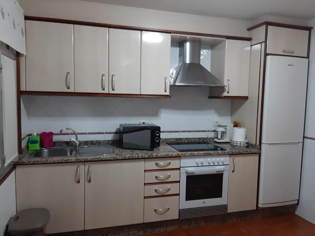 Ponteceso的住宿－BERGANTIÑOS 41,1º izd，厨房配有白色橱柜、水槽和微波炉