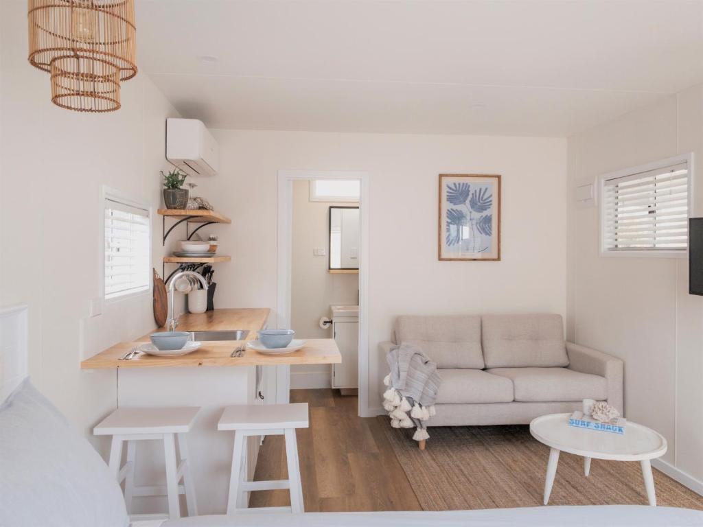 a living room with a couch and a table at Little Palm Cabins in Lake Cathie