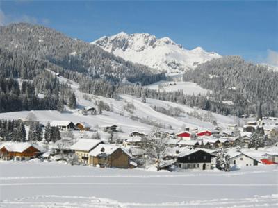 eine kleine Stadt im Schnee mit einem Berg in der Unterkunft Appartements Haus Bergland in Sankt Martin am Tennengebirge