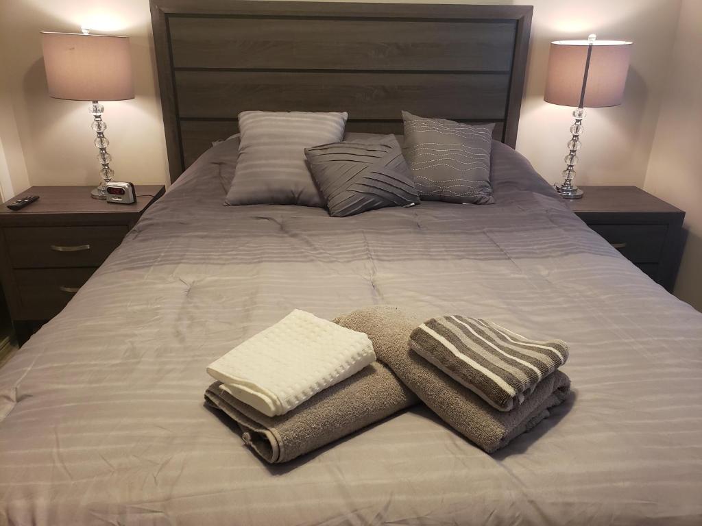 a bed with towels and pillows on it with two lamps at Coral Springs Paradise in Coral Springs