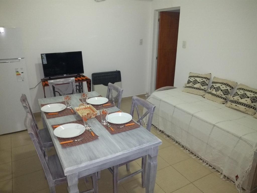 sala de estar con mesa y sofá en Departamento los sunchos en Sunchales