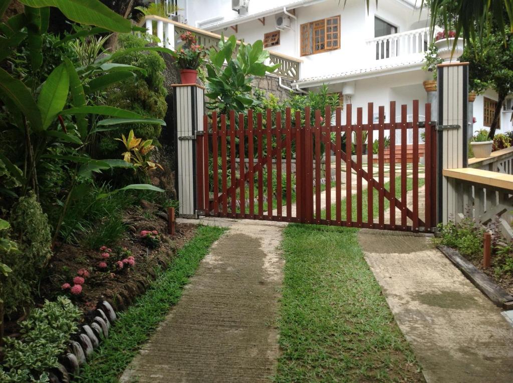 um portão vermelho em frente a uma casa em Cavern Apartments em Baie Sainte Anne