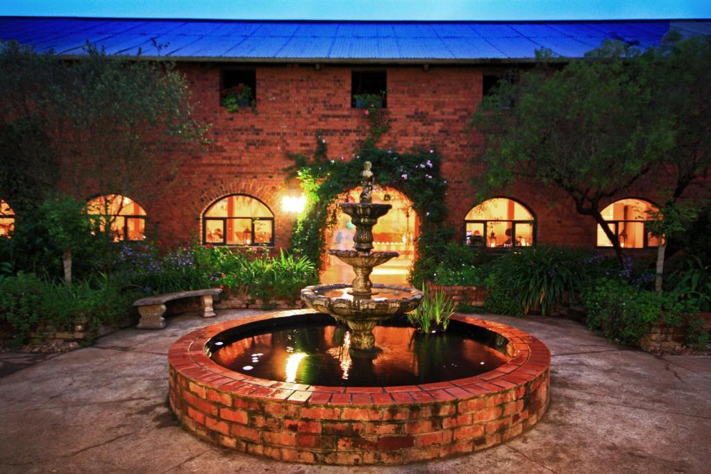a fountain in front of a brick building at Kings Grant Country Retreat in Ixopo