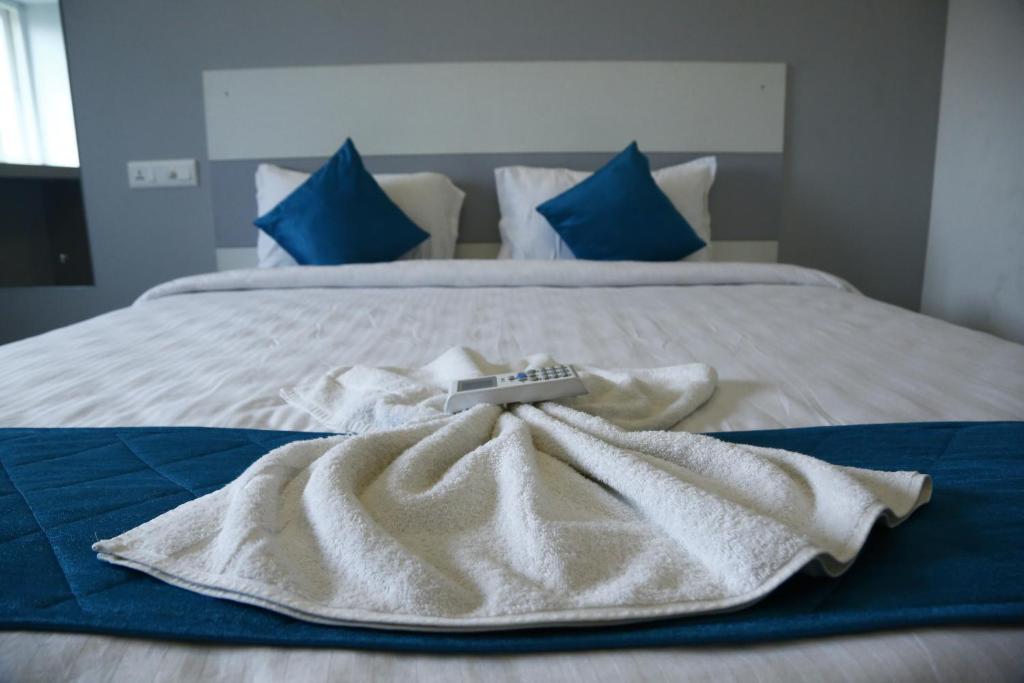 a bed with white towels on it with blue pillows at The Base Inn (where convenience meets luxury) in Pondicherry