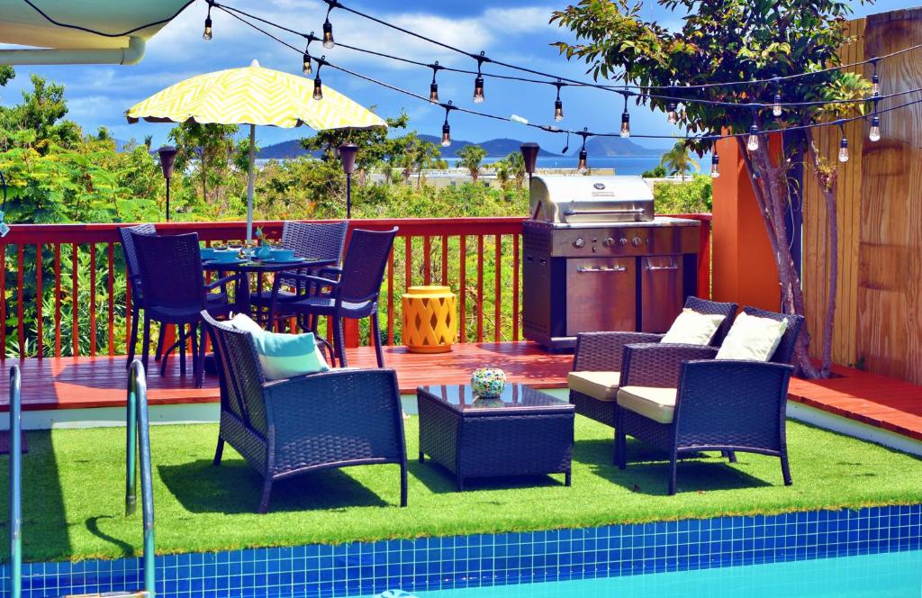 a patio with chairs and a table and a grill at Pavilions and Pools Resort in Frydendal
