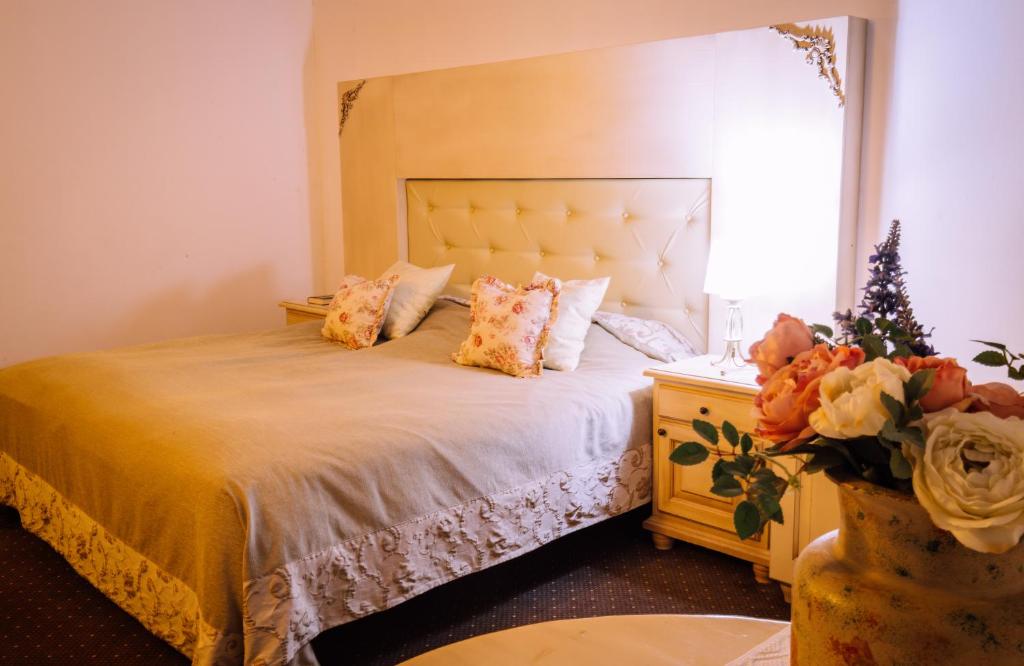 um quarto com uma cama, uma janela e flores em Pensiunea Ghiocelul em Avrig