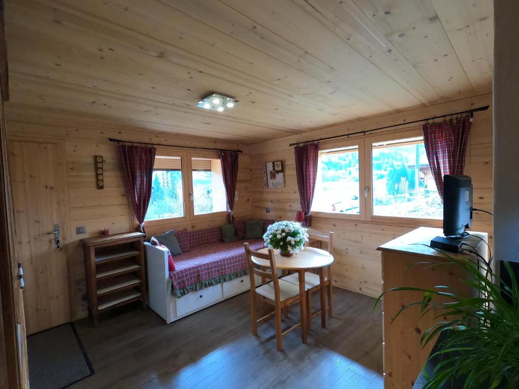 a room with a bed and a table in a cabin at L'esquirot in Megève