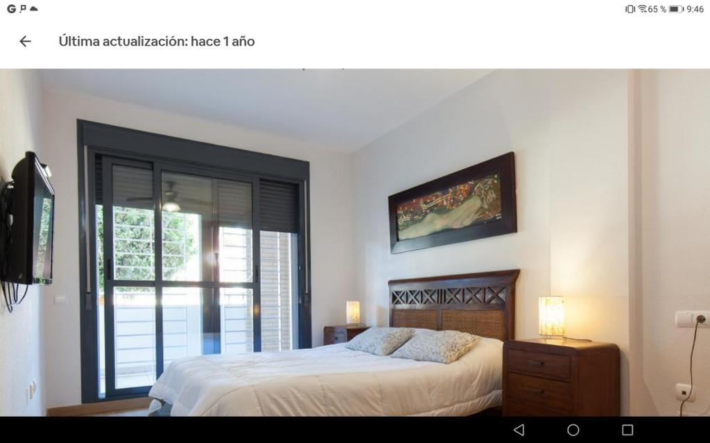 a bedroom with a large bed and a window at Calle Austria in Roquetas de Mar