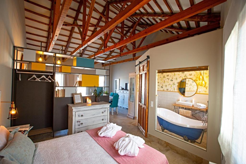 - une chambre avec un lit et une baignoire dans l'établissement El Patio de los Jazmines Boutique-House, à Consuegra