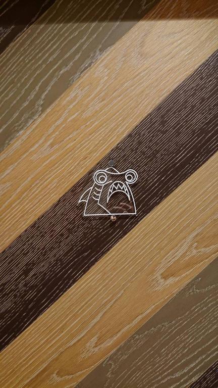 a drawing of a face on a wooden table at Shark B&B in Hengchun