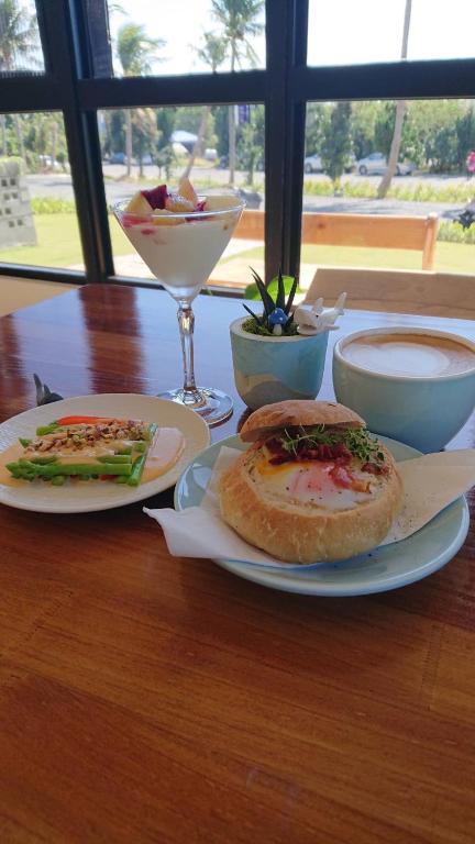 a table with two plates of food and a drink at Shark B&B in Hengchun
