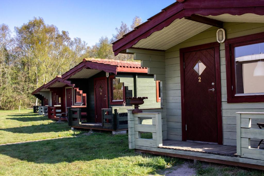 une rangée de cottages garés dans une cour dans l'établissement Limfjords hytter, à Roslev