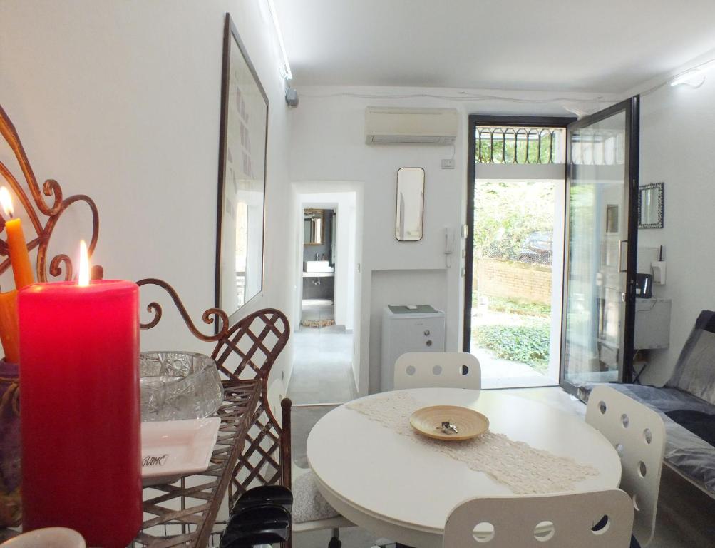 a living room with a table and a red candle at LOFT GARDEN in Bologna's heart OSPEDALE RIZZOLI in Bologna