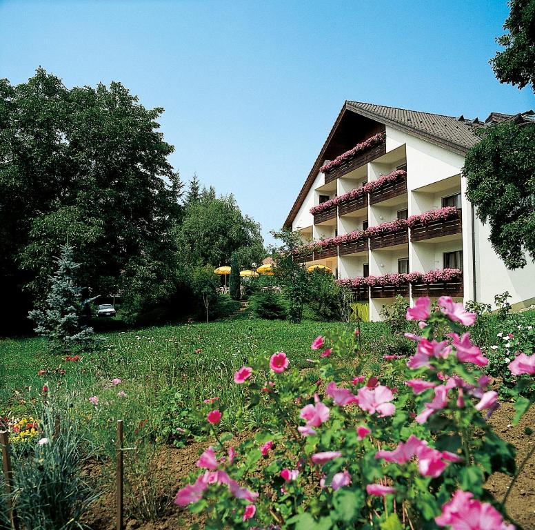 a building with pink flowers in front of it at Hotel garni zur Weserei in Kandern