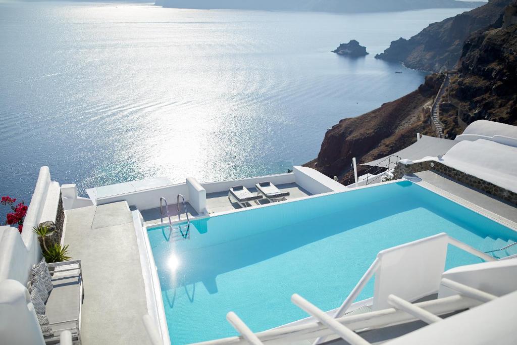 a view from a balcony overlooking the ocean at La Perla Villas and Suites - Adults Only in Oia