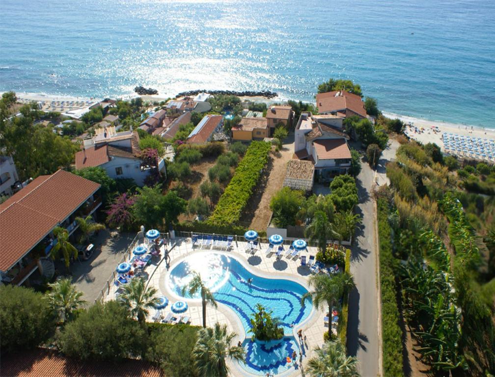 an aerial view of a resort with a pool and the ocean at Tonicello Hotel Resort & SPA in Capo Vaticano