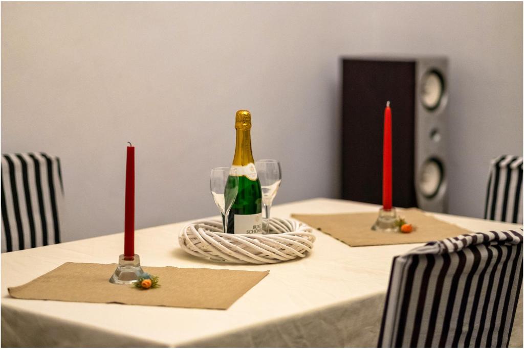 un tavolo con due candele rosse e una bottiglia di vino di Clucerului Sun Residence Villa a Bucarest