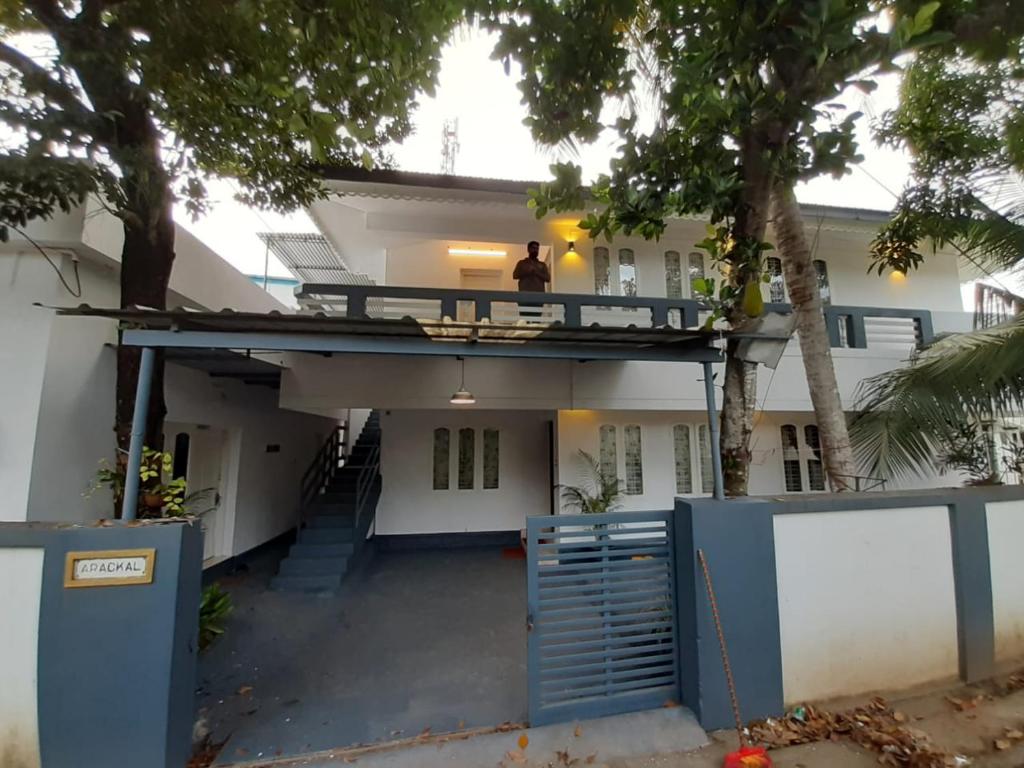 a man standing on the balcony of a house at Beachway Inn in Alleppey