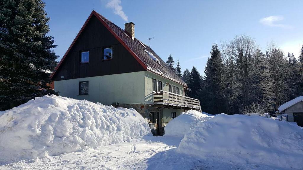 dom z kupą śniegu przed nim w obiekcie Chalupa 387 w mieście Harrachov