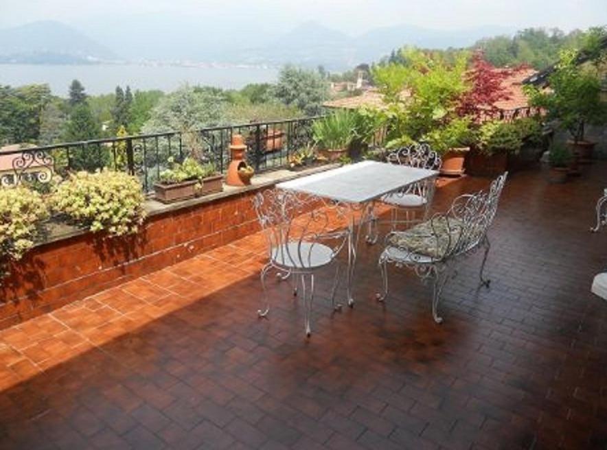a patio with a table and chairs on a balcony at Terrazza con Vista Grande in Laveno-Mombello