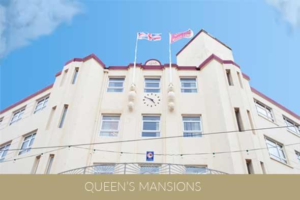 ein Gebäude mit einer Uhr auf der Vorderseite in der Unterkunft Queens Mansions: Queens Suite in Blackpool